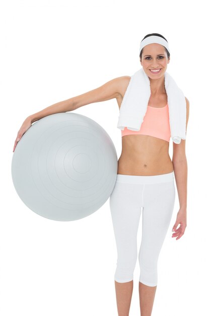 Portrait of a smiling fit woman holding fitness ball