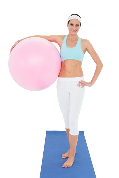 Portrait of a smiling fit woman holding fitness ball