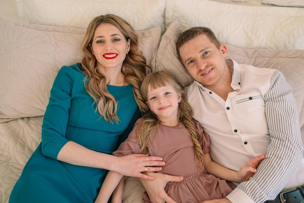 Photo portrait of smiling friends sitting on bed at home