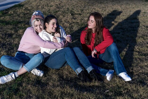 Portrait of smiling friends sitting on field