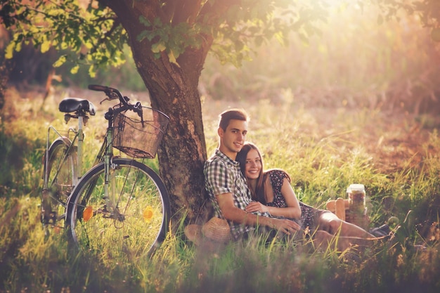 Foto ritratto di amici sorridenti seduti sul campo erboso del parco