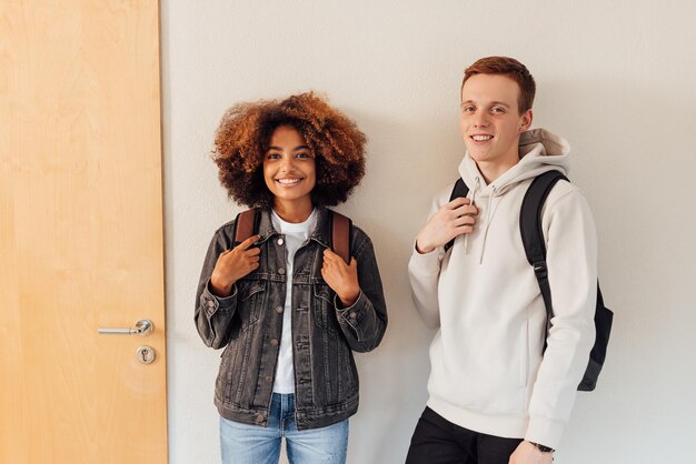 Photo portrait of smiling friends standing against wall