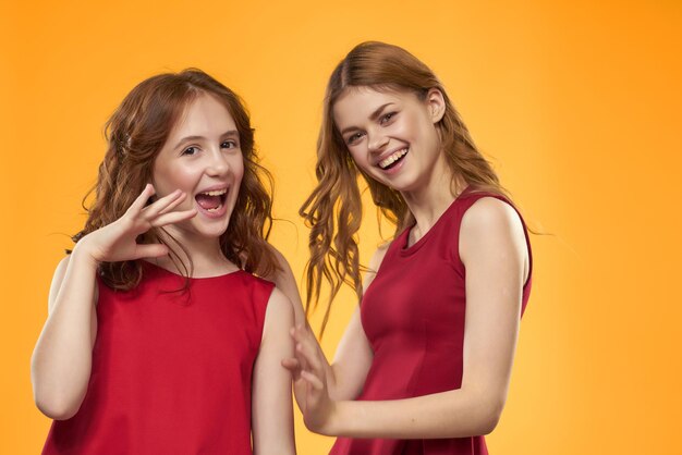 Portrait of smiling friends standing against yellow background