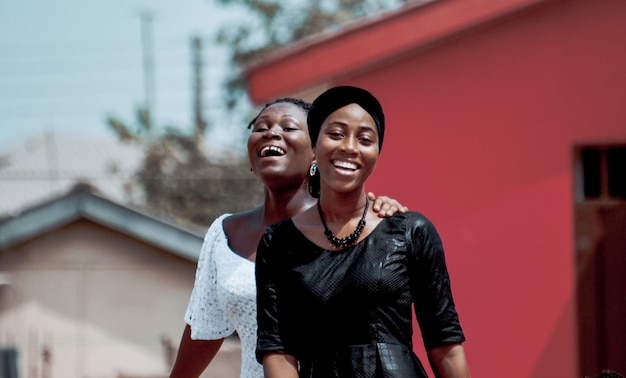 Portrait of smiling friends with arm around in city