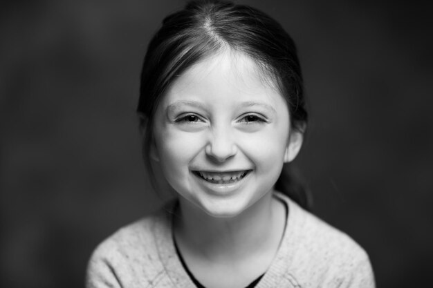 Photo portrait of smiling girl against gray background