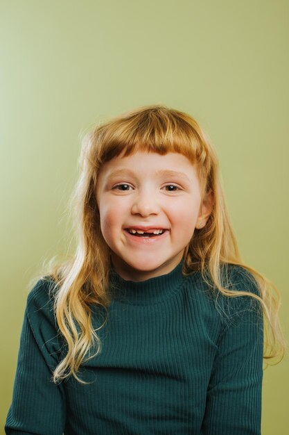 Photo portrait of smiling girl against green background