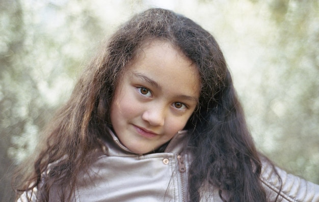 Foto ritratto di una ragazza sorridente contro gli alberi