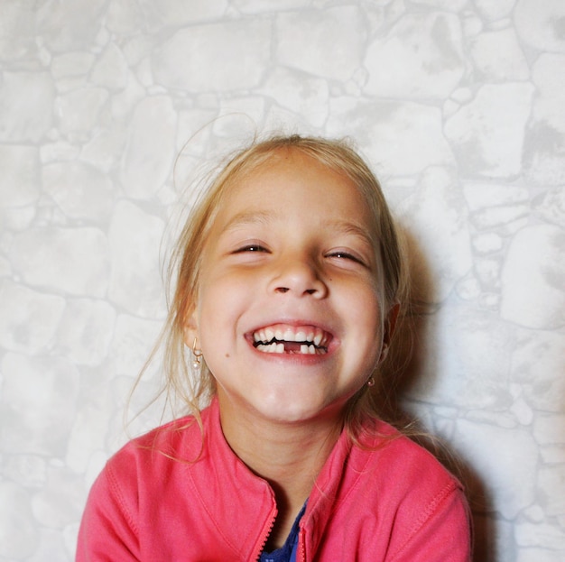 Photo portrait of smiling girl against wall