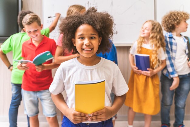 Photo portrait of smiling girl holding book