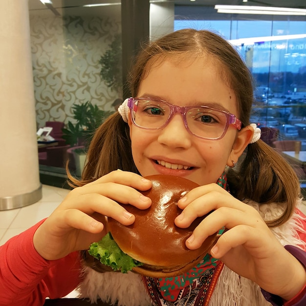 햄버거를 들고 있는 웃는 소녀의 초상화
