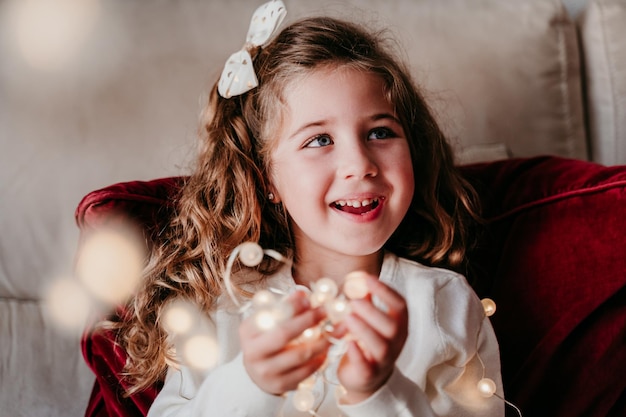 Photo portrait of smiling girl holding indoors at home