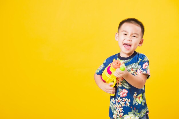 Portrait of a smiling girl holding yellow background