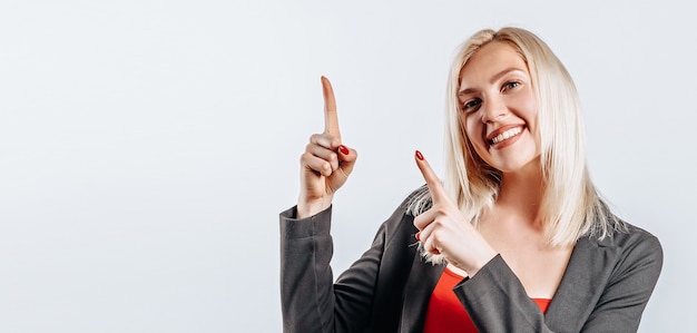 Ritratto di una ragazza sorridente che punta il dito verso l'alto