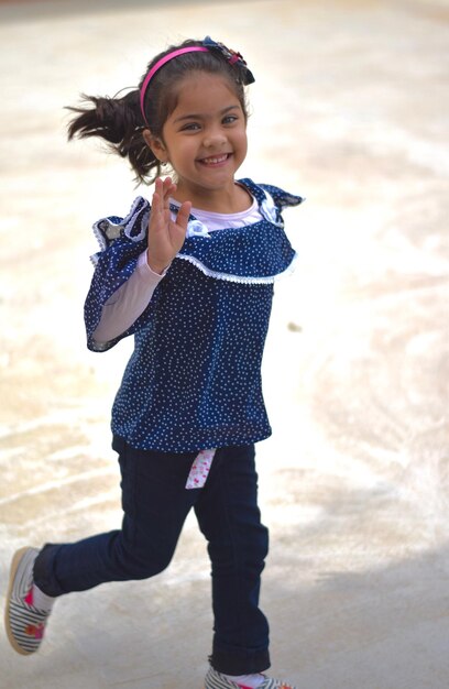 Photo portrait of smiling girl running on footpath