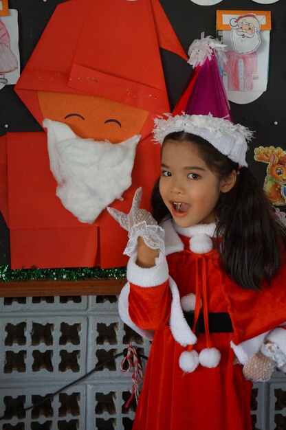 Foto ritratto di una ragazza sorridente in costume di babbo natale