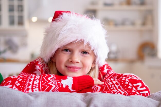 Portrait smiling girl in Santa hat and Christmas costume at home