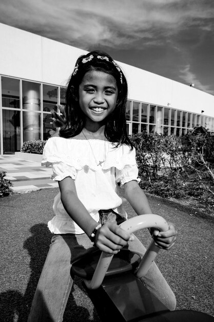 Photo portrait of smiling girl sitting on seesaw