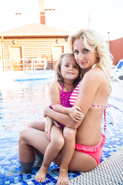 Portrait of a smiling girl sitting in swimming pool