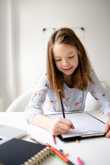 Photo portrait of a smiling girl sitting on table