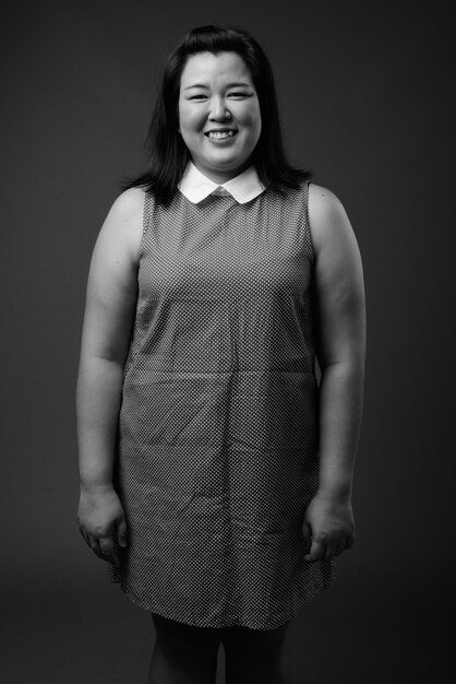 Portrait of smiling girl standing against black background