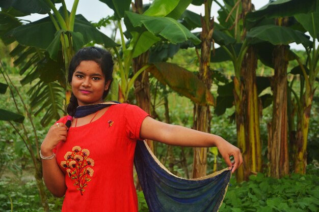 Photo portrait of smiling girl standing by plants