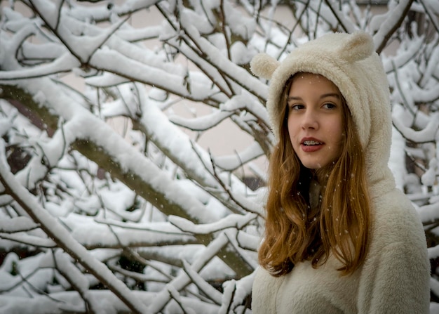 Foto ritratto di una ragazza sorridente in piedi nella neve