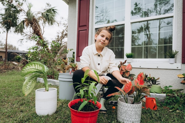 Photo portrait of smiling girl  surrounded by potted plant