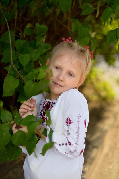 Portrait of a smiling girl with a flower in a Ukrainian embroidered shirt Ukrainian traditions