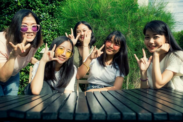 Portrait of smiling girls with teacher sitting outdoors