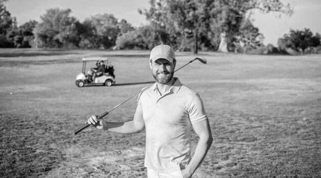 Photo portrait of smiling golfer in cap with golf club summer