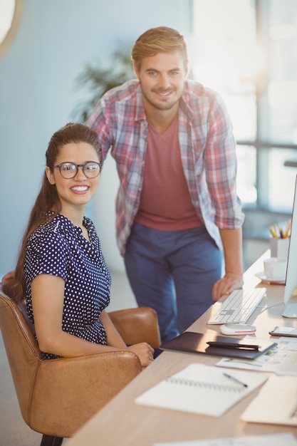 Portrait of smiling graphic designers at desk