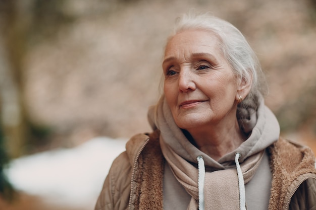 Portrait of smiling gray haired elderly woman outdoor.