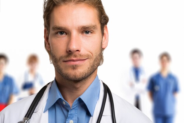 Portrait of a smiling handsome doctor in front of his team