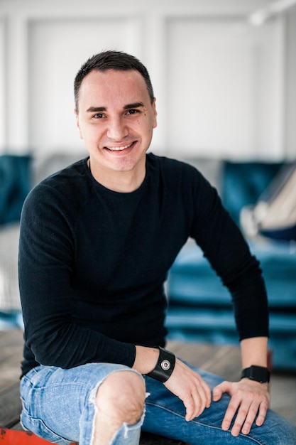 Photo portrait of smiling handsome man sitting on table