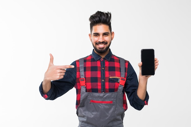 Portrait of smiling handyman showing screen of mobile phone on white space