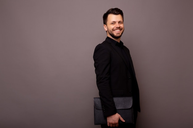 Portrait of smiling happy bearded businessman in black classic suit