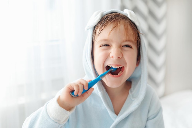 Ritratto di bambino felice sorridente che lava i denti con lo spazzolino da denti igiene dentale della routine mattutina delle cure mediche del ragazzino