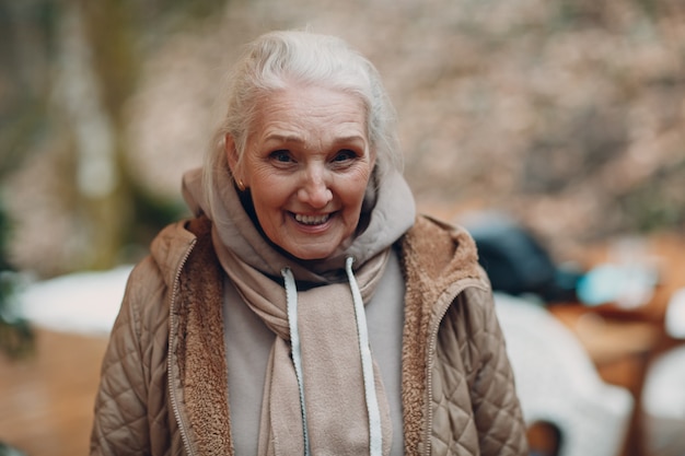 Portrait of smiling happy elderly old woman outdoor and looking to camera