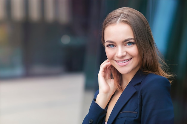 幸せな若いビジネス女性を屋外で笑顔の肖像画