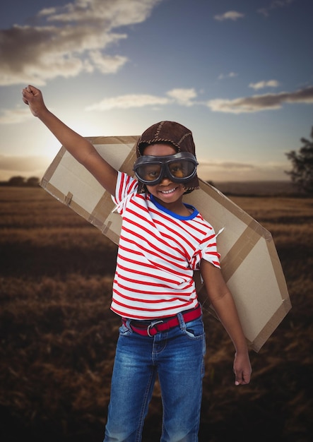 Photo portrait of smiling kid pretending to be a pilot in field