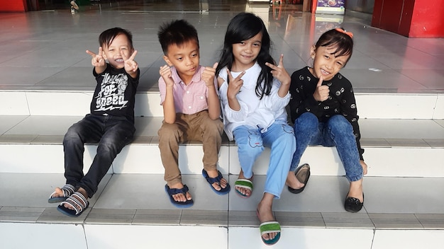 Photo portrait of smiling kids sitting on steps