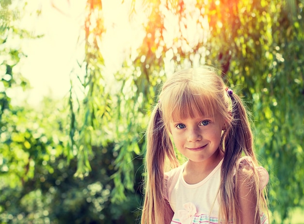 여름에 공원에서 미소 짓는 작은 소녀의 초상화