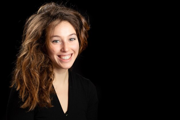 Portrait of smiling long brownhaired girl isolated on black background