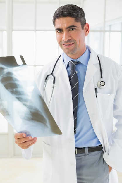 Portrait of a smiling male doctor holding xray