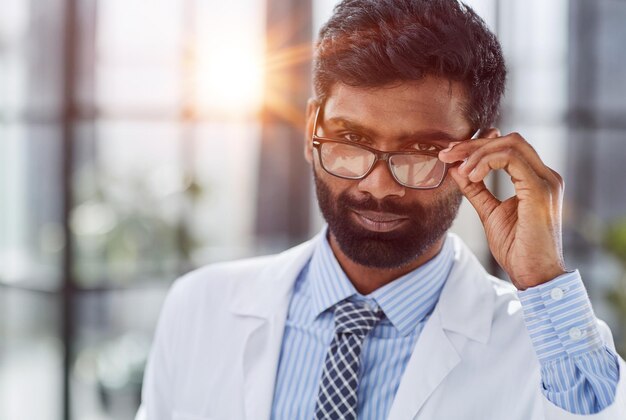 Portrait of a smiling male doctor standing in a hospital corridor