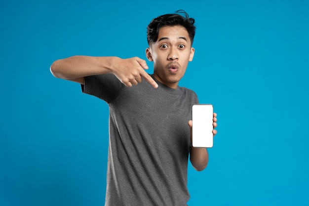 Portrait of smiling male holding smart phone with white blank screen in hand