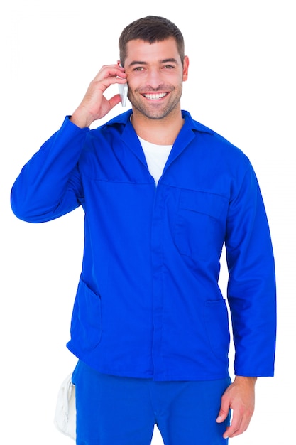 Portrait of smiling male mechanic using mobile phone