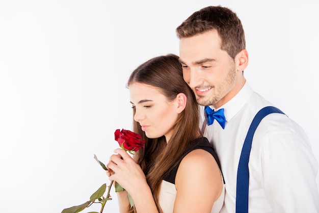 Portrait of smiling man and attractive woman holding red rose