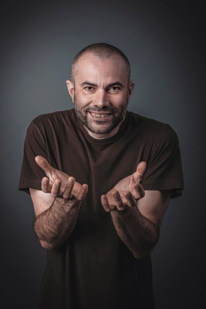 Photo portrait of smiling man gesturing against gray background