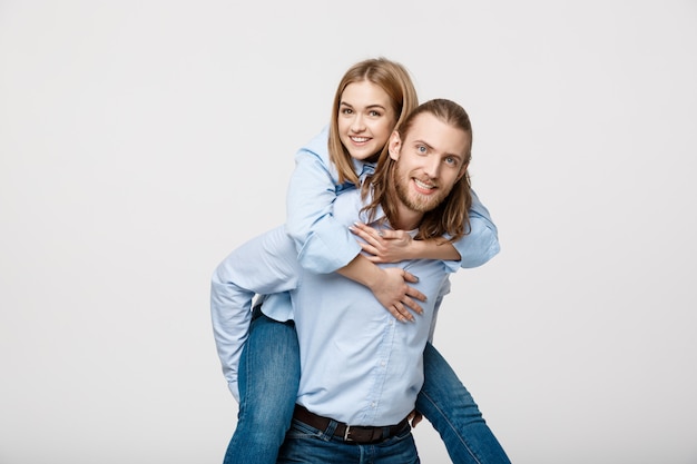 Portrait of smiling man giving happy woman a piggyback ride